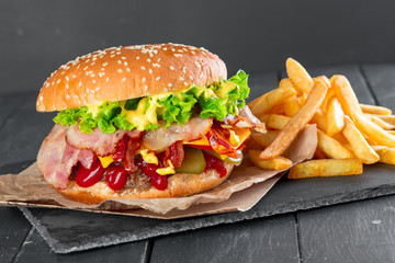 Hamburger with fries on a slate plate