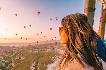 young woman watching sunrise from hot air balloon Cappadocia Turkey