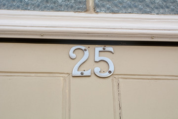 House number 25 sign at top of door