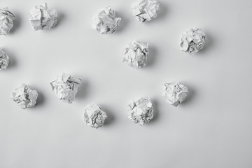 top view of spilled crumpled papers on white surface