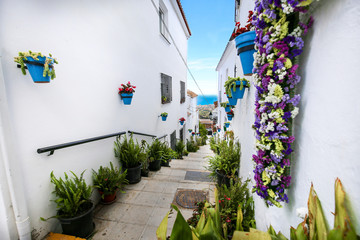 ruelle de maisons blanches et et pots de fleur bleus 1