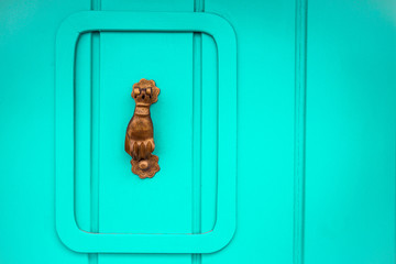 herutoir de porte (main) sur porte en bois turquoise