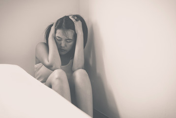 Asian woman depression have a headache in bedroom,Black and white toned