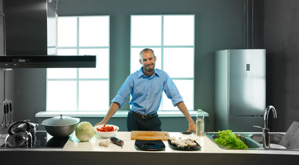 A happy man at home cooking food