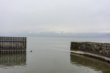 stone harbour at lake in winter with snow mountain landscape
