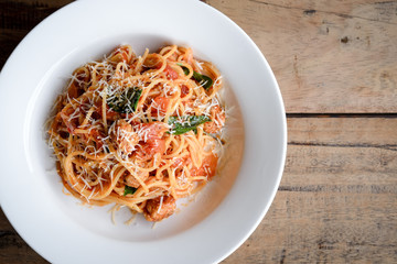 Top view of spaghetti shrimp on a white plate on wooden.