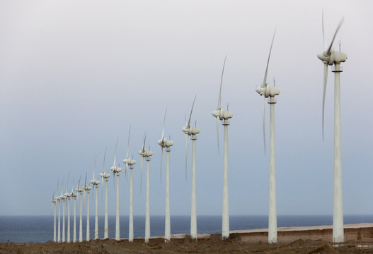 Wind turbines in a row by the sea in Arinaga, Gran Canaria. Renewable clean energy, sustainability, eco friendly resources concepts