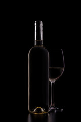 Silhouette of white wine bottle with half glass isolated on black dark background with soft reflections and beautiful shadows. Studio shot.