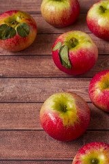 Fresh red apples with green leaves on a Dark wooden background.