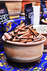 a big pot of dry cinnamon sticks and other spices for sale in a market