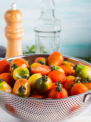 Italian tomatoes in a colander on table. Cooking with tomatoes concept. Local organic vegetables