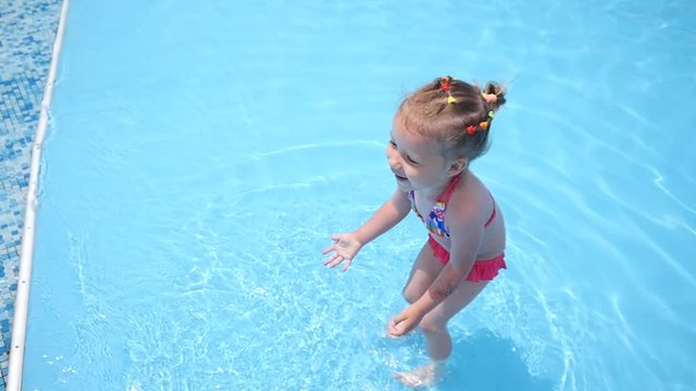 Little kid girl have fun enjoy swim in a swimming pool clear water on summer resort