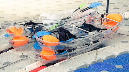 Transparent plastic canoes stay on port.