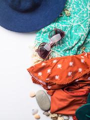 Naklejka premium Beach female fashion accessories swimsuit, sun glasses, hat, flip flops, towel and bag. Summer traveling holiday concept flat lay