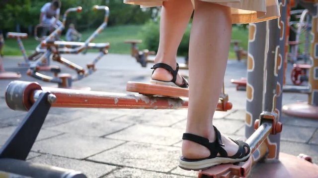 Fitness training ground in the park - woman legs twist the bicycle pedals