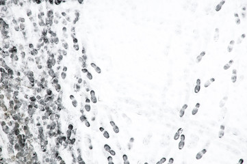 background: human old and new footsteps in the fresh converge on wet snow in the winter