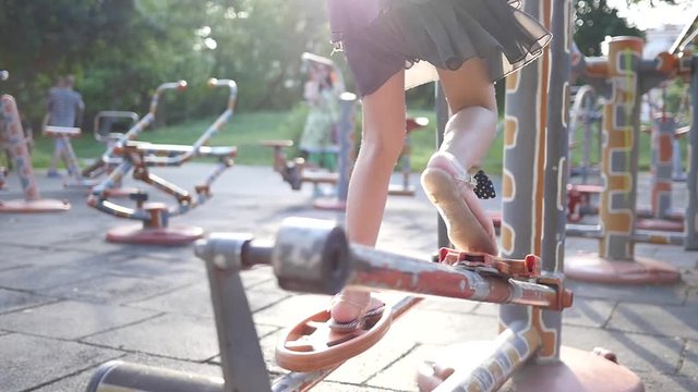 Fitness training ground in the park - kid girl legs twist the bicycle pedal slow motion