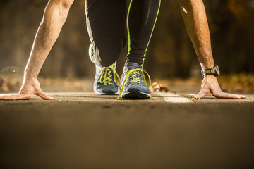 Ready to go! low angle photo of shoe of male athlete on the tarmac, preparing for a run. autumn  morning