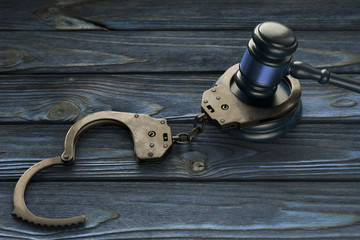 hammer of a judge, handcuffs on a wooden background. crime