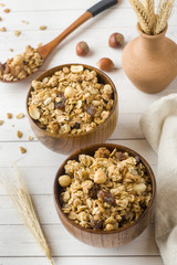 Dry Breakfast of oat flakes, granules and nuts. Muesli in a deep wooden plate.