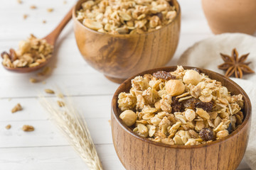 Dry Breakfast of oat flakes, granules and nuts. Muesli in a deep wooden plate.