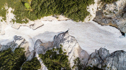 Aerial view of the mudflow with snow high in the Alpine mountains, Top view