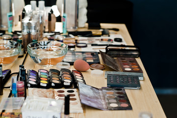 Close-up photo of make-up brushes, eyeshadows, powder in beauty salon.