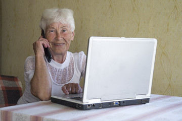 woman with phone using laptop