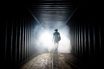Light at the end of the tunnel. Silhouette of people in dark passage