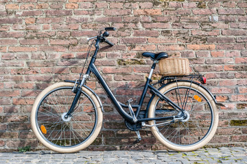 Fototapeta na wymiar Black retro vintage bicycle with old brick wall.