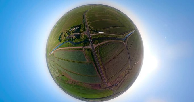 agricultural, cultivated fields with irrigational channel spherical little planet view. Agricultural landscape rows. Irrigated farmland. Countryside with fields of crops.