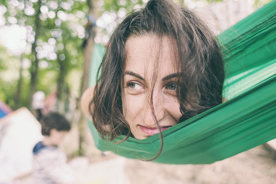 The woman lies in a hammock.