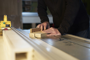 Joinery tools. Carpenter holding a measure tool, wood part, making furniture on the work table.