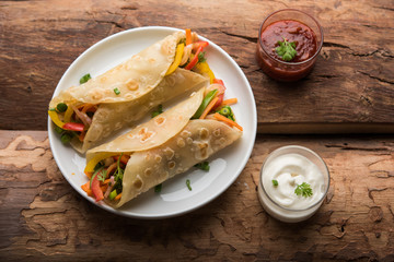 Indian Veg chapati Wrap / Kathi Roll, served in a plate with sauce over moody background. selective focus
