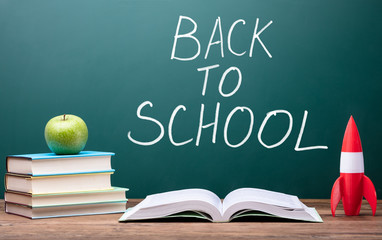 Schoolbooks With Rocket And Green Apple