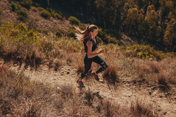 Naklejka premium Woman trail runner training for cross country run