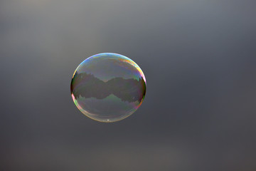 A colorful soap bulb with reflections of a street scene on the christopher street day 2018 in Berlin-Germany.