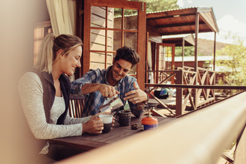 Couple on holiday having coffee in morning - obrazy, fototapety, plakaty