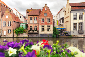 Fototapeta na wymiar Nice view of picturesque medieval houses on the quay of Leie river and flowers, Old Town of Ghent, Belgium