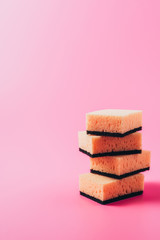 close up view of stack of washing sponges, pink background