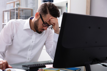 Stressed Businessman Sitting In Office