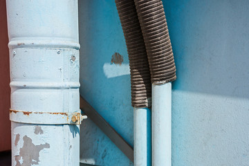 Down pipe and corrugated hose against the wall