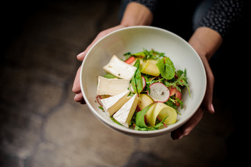 Girl holding a plate of a delicious salad
