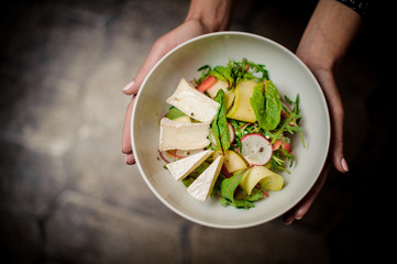 Woman holding a plate of a delicious salad