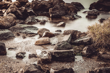 The wild sea beach with stones at sunrise. Big stones on the beach. Morning inflow of water. Nessebar. Bulgaria
