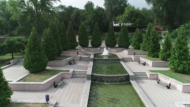 Dron flies from the fountain in a park in the middle of the city