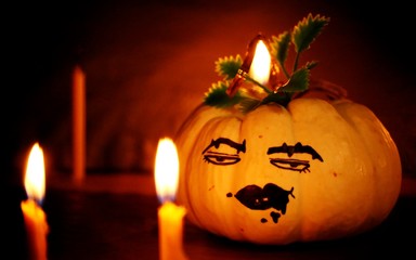 Halloween pumpkin face and lighting candle blur background