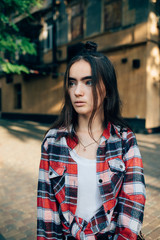 Fototapeta premium Vertical portrait of young female wearing plaid red shirt