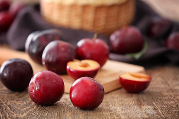 Ripe juicy plums on table