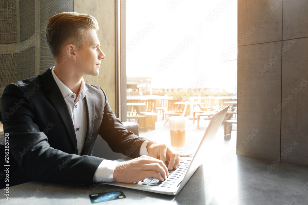 Sticker Young man using laptop at table